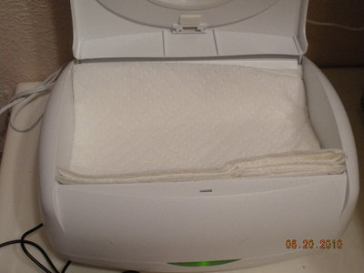 Warmer with paper towels on top of dishtowel.